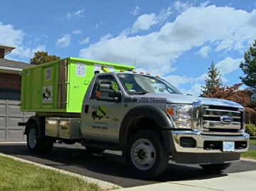 A junk removal franchise service truck parked on a residential street.